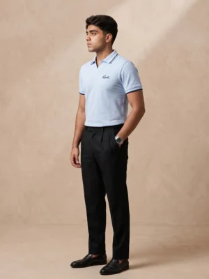 Model wearing Orphic men's sky blue tipped piqué polo with black trousers, front view