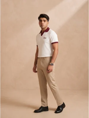 Model wearing Orphic men's white ribbed polo with maroon collar, open placket and chest embroidery, front view