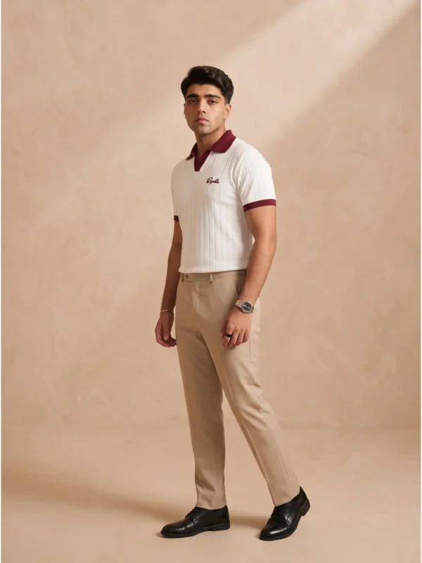 Model wearing Orphic men's white ribbed polo with maroon collar, open placket and chest embroidery, front view