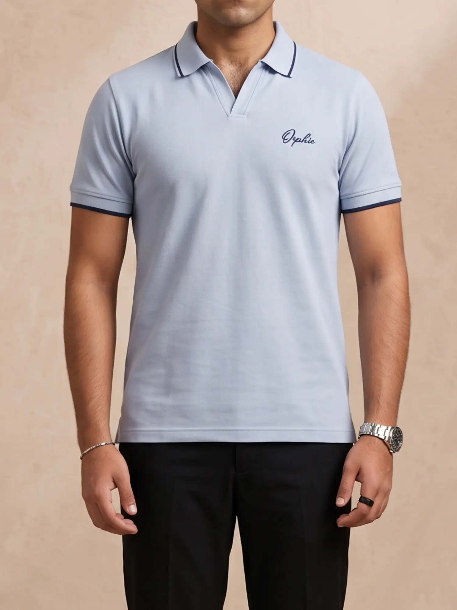Close-up of Orphic men's sky blue piqué polo showing navy-tipped collar and chest embroidery