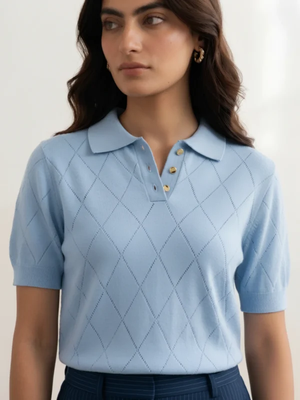 Women's powder blue polo with gold buttons and diamond pointelle knit, front view.webp