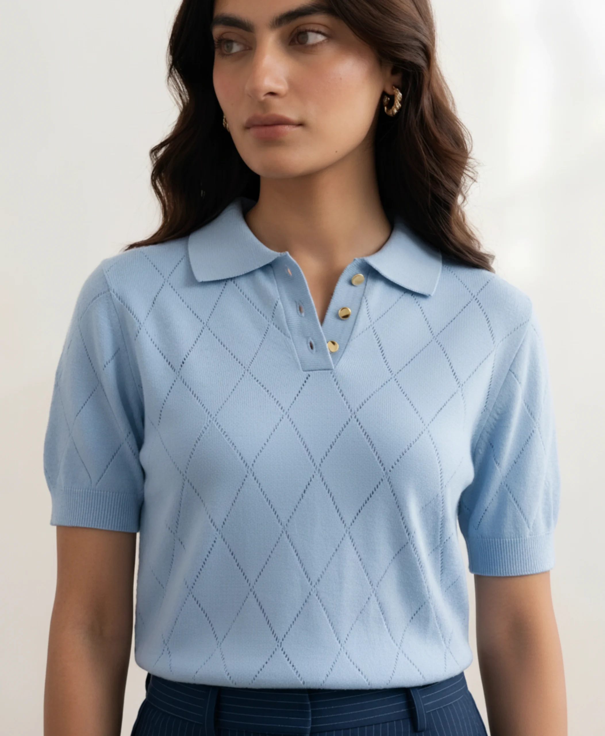 Women's powder blue polo with gold buttons and diamond pointelle knit, front view.webp