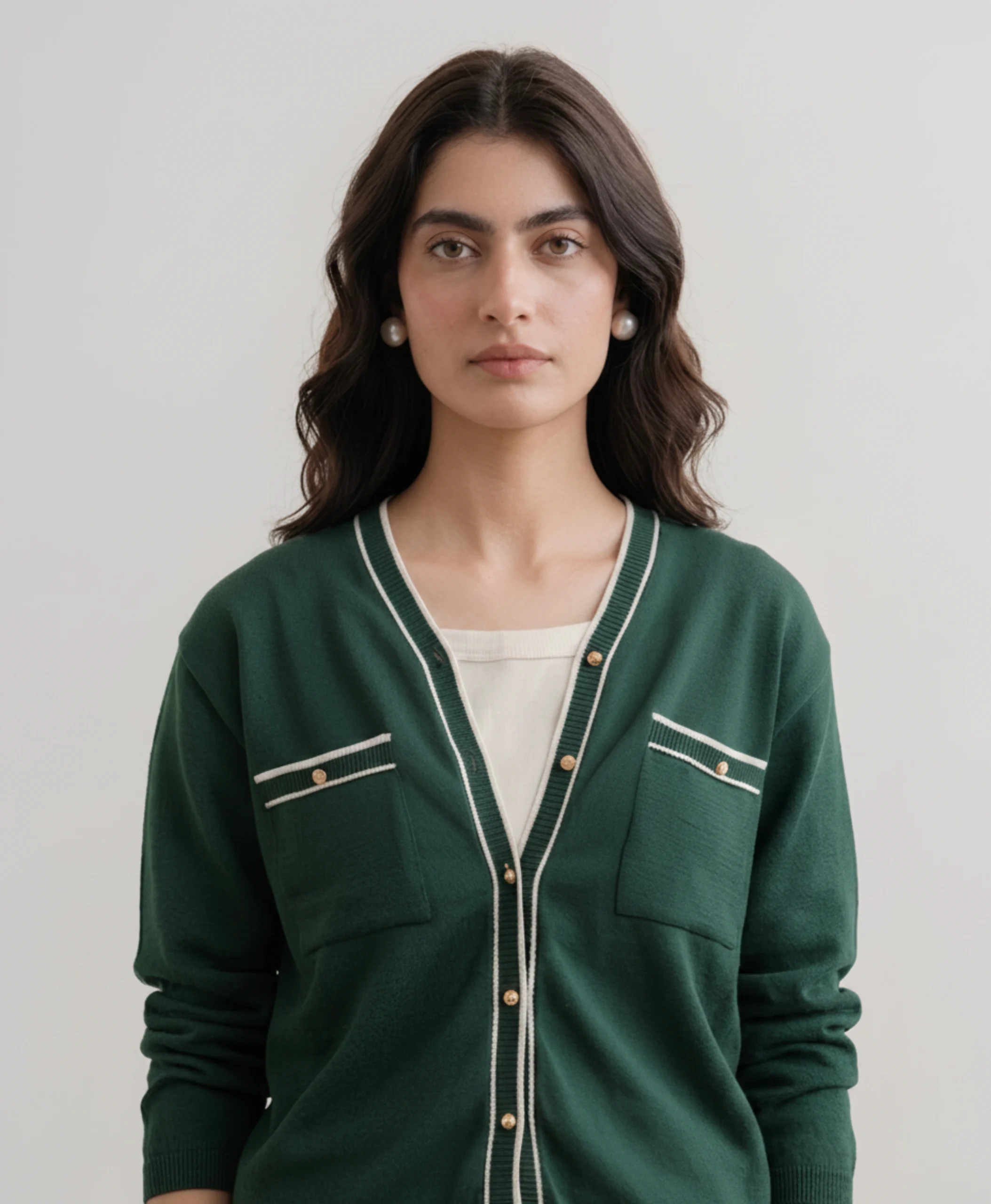 Women's green tipped cardigan chest pocket and gold button detail.webp