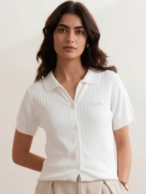 Women's white ribbed knit polo front view with open collar and cream Orphic embroidery.webp