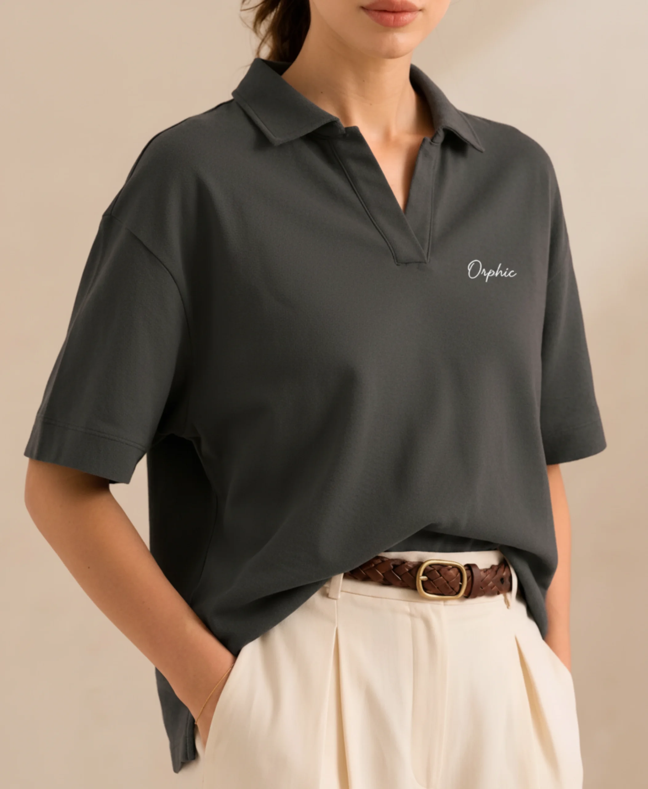 Close-up of women's charcoal polo showing open collar and cream embroidery.webp