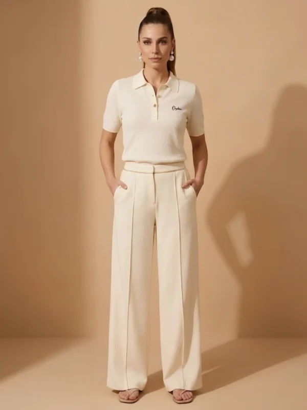 Woman wearing Orphic ivory knit polo with gold buttons, front view.wwebp