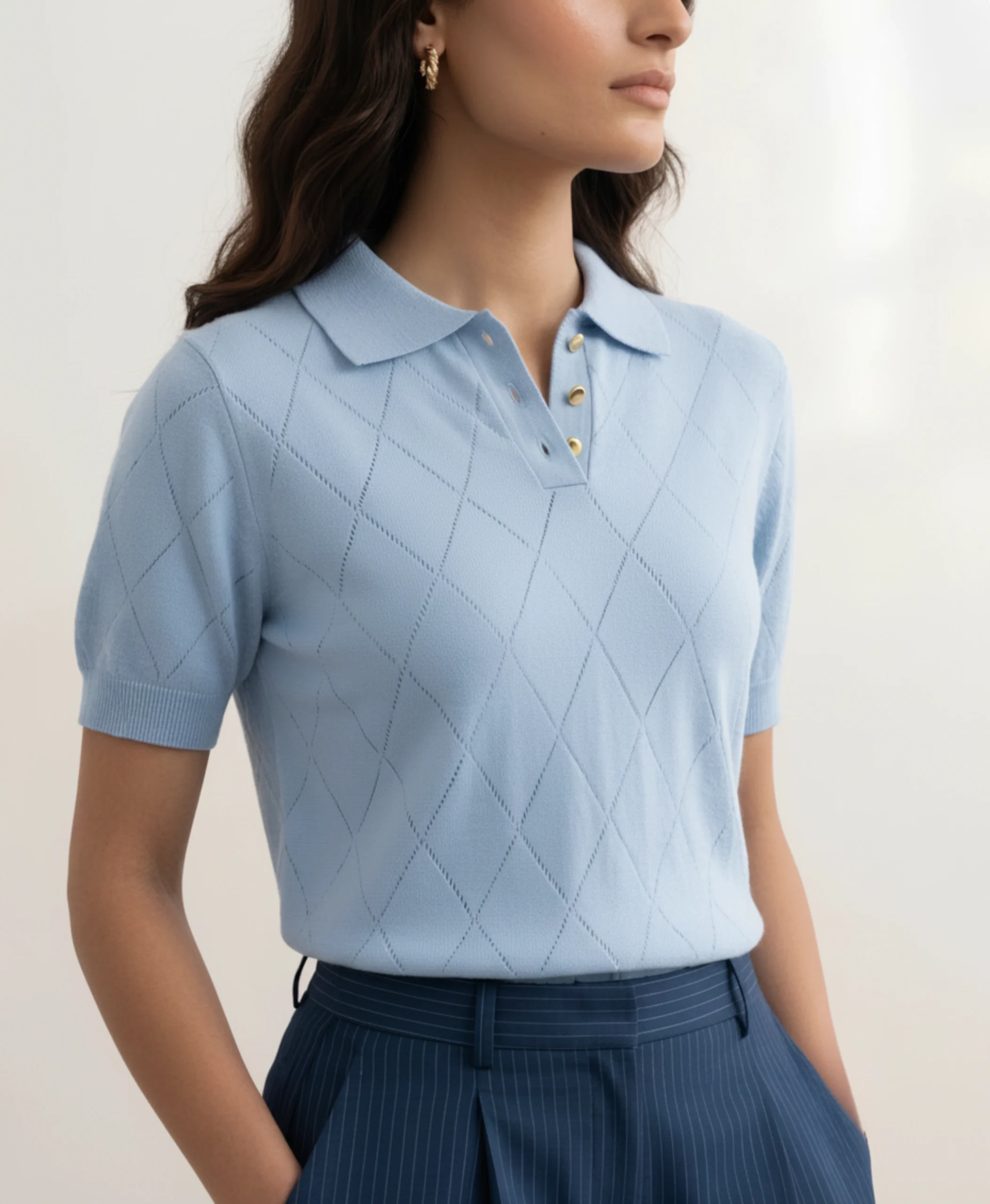 Close-up of women's powder blue polo showing diamond pointelle knit and gold buttons.webp