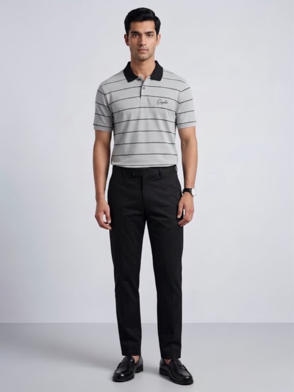 Model wearing Orphic men's grey striped polo with black collar, front view with black trousers