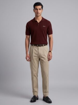 Model wearing Orphic men's maroon cable-knit polo with open collar, front view with tan trousers