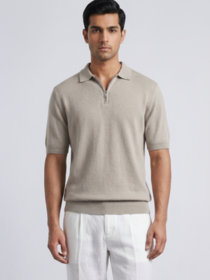 Model wearing Orphic men's oatmeal knit quarter-zip polo, front view with white trousers
