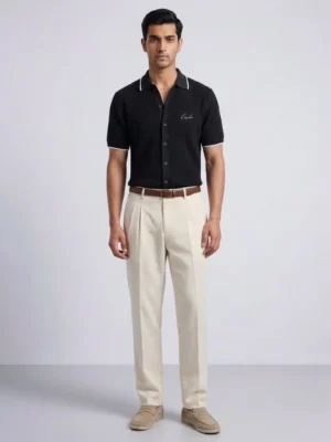 Men's black knit polo with cream-tipped collar, front view