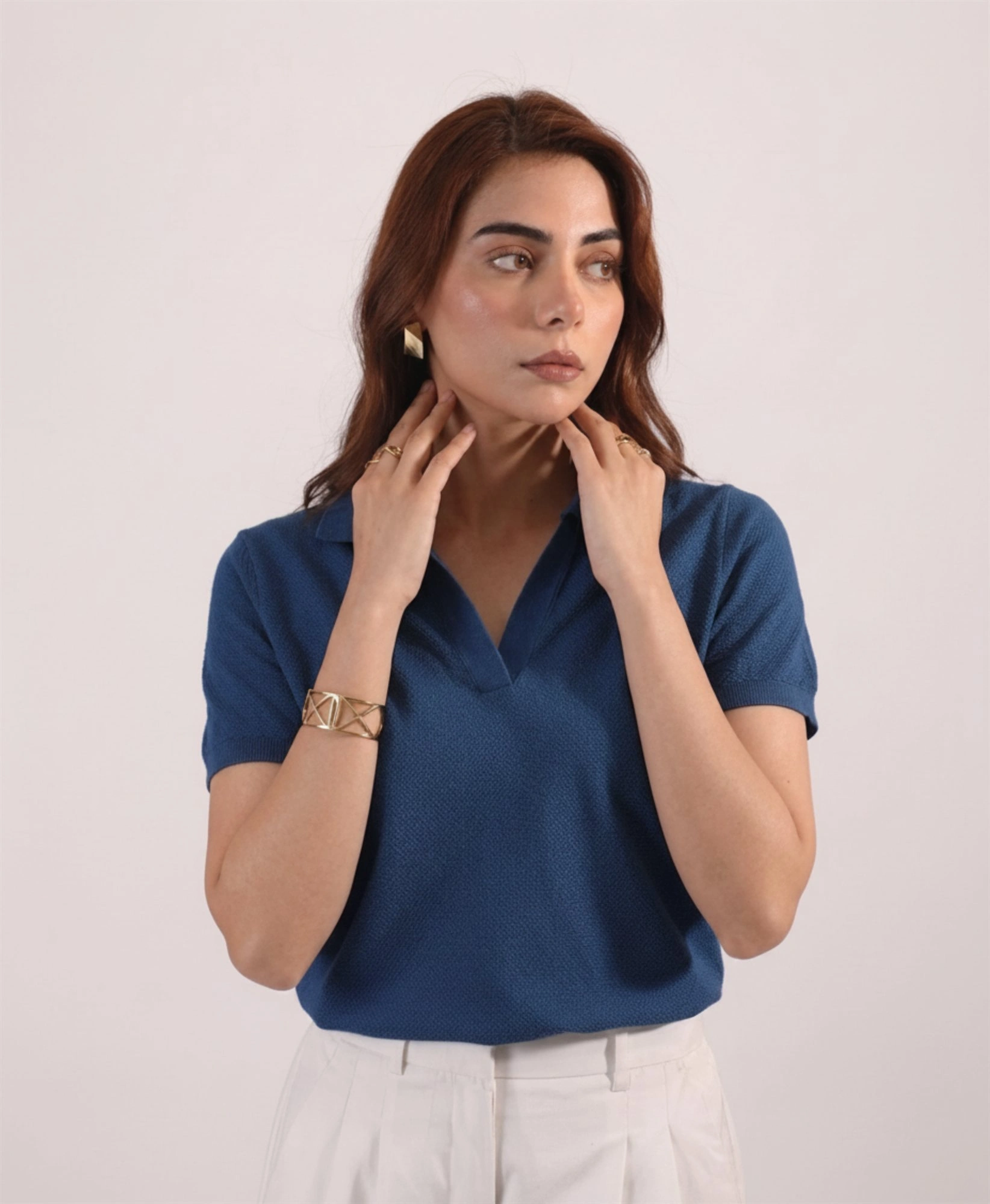 Women's denim blue open-collar knit polo, front view with cream trousers