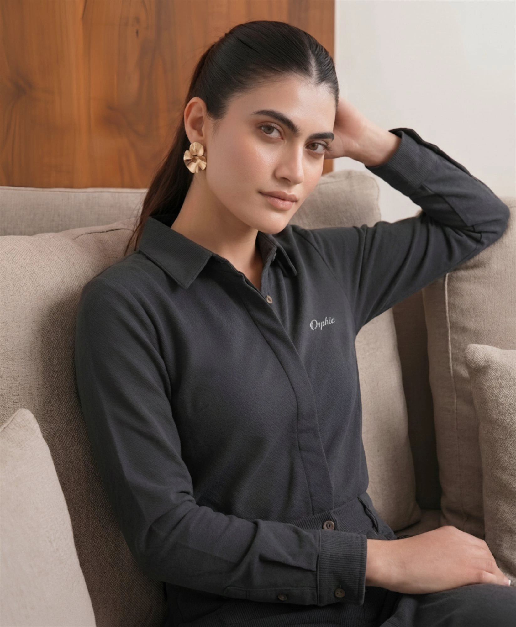 Model seated wearing Orphic women's charcoal knit shirt
